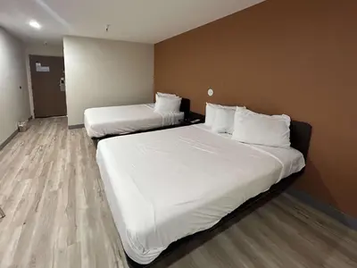 two beds in a hotel room with white sheets at Studio 6 Suites Cameron Park, CA Folsom in Cameron Park