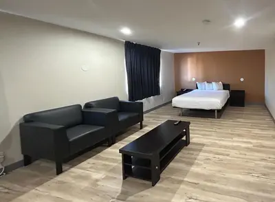 a hotel room with a bed and a couch at Studio 6 Suites Cameron Park, CA Folsom in Cameron Park