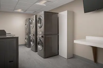 a laundry room with three washer and dryer machines at Residence Inn by Marriott Modesto North in Modesto