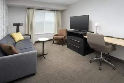 a living room with a couch and a desk with a television at Residence Inn by Marriott Modesto North in Modesto