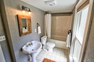 a bathroom with a white toilet and a sink at The Groveland Hotel in Groveland