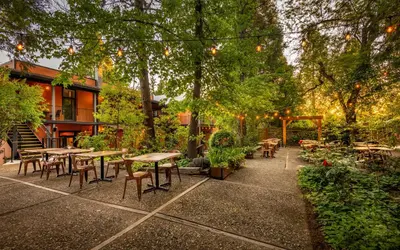 a patio with tables and chairs in a garden at The Groveland Hotel in Groveland