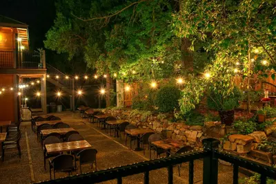a row of tables and chairs in a garden at night at The Groveland Hotel in Groveland