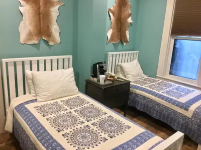 two beds in a room with blue walls at The Groveland Hotel in Groveland