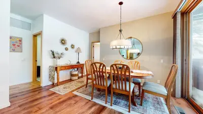 a dining room with a table and chairs and a mirror at Snowcreek 887 Condo in Mammoth Lakes