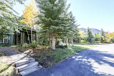a house with a tree on the side of a road at Snowcreek 887 Condo in Mammoth Lakes