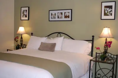 a bedroom with a large white bed with two lamps at El Rancho Motel in Bishop