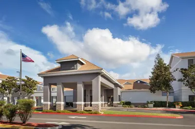 a building with an american flag on a street at Homewood Suites by Hilton Fresno in Fresno