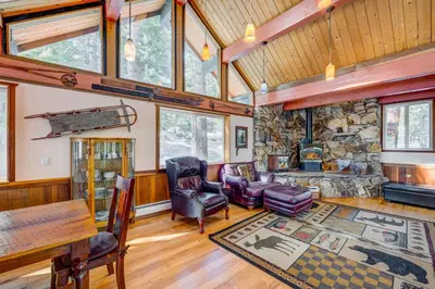 a living room filled with furniture and a stone fireplace at Peaceful Forest Retreat in Carnelian Bay