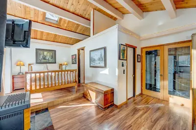 a living room with a staircase and a tv at Peaceful Forest Retreat in Carnelian Bay