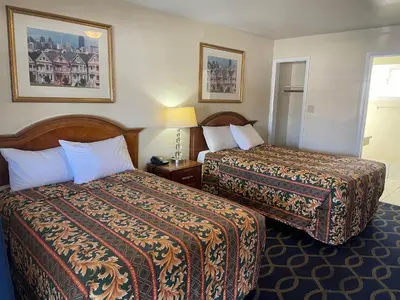 a hotel room with two beds and a lamp at Holiday Motel Oakdale in Oakdale
