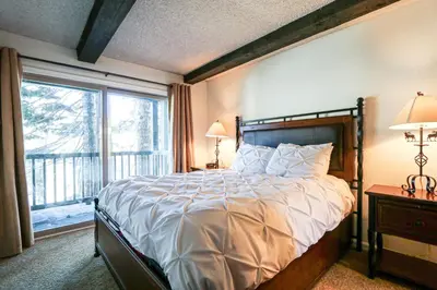 a bedroom with a large bed and a large window at Chamonix Condo 94 Condo in Mammoth Lakes