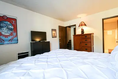 a bedroom with a large white bed and a television at Chamonix Condo 94 Condo in Mammoth Lakes
