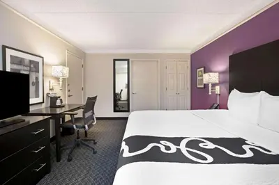 a hotel room with a large bed and a desk at La Quinta Inn by Wyndham Fresno Yosemite in Fresno