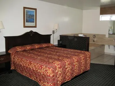 a hotel room with a bed and a bath tub at Jamestown Railtown Motel in Jamestown
