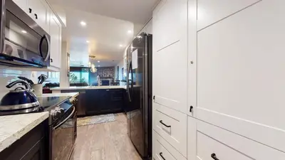 a kitchen with white cabinets and a black refrigerator at Bridges #209 Condo in Mammoth Lakes