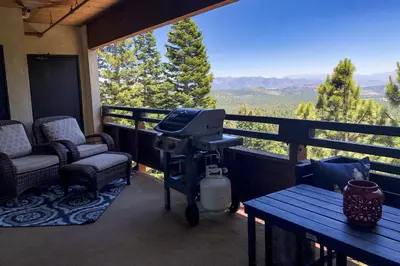 a screened in porch with a grill and a table and chairs at Bridges #209 Condo in Mammoth Lakes