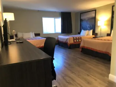 a hotel room with two beds and a desk at Hotel Elevation in South Lake Tahoe