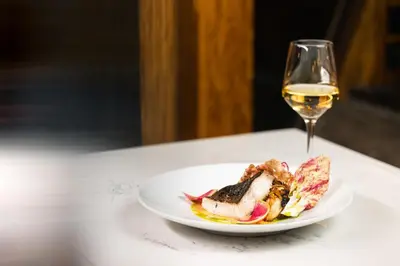 a plate of food and a glass of white wine at Gravity Haus Truckee-Tahoe in Truckee