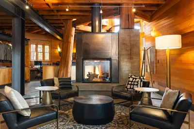 a lobby with a fireplace and chairs and a table at Gravity Haus Truckee-Tahoe in Truckee