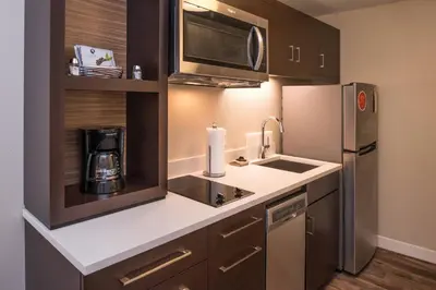a kitchen with a sink and a refrigerator at TownePlace Suites by Marriott Merced in Merced