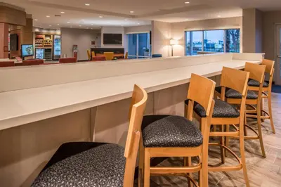 a bar in a waiting room with chairs at TownePlace Suites by Marriott Merced in Merced