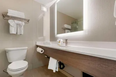 a bathroom with a toilet and a sink with a mirror at Best Western Plus Sparks-Reno Hotel in Reno