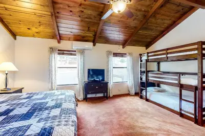 a bedroom with a bunk bed and a tv at Creekside Cabin in Groveland