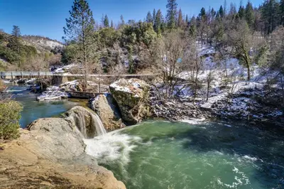 a waterfall in a river with rocks and trees at Creekside Cabin in Groveland