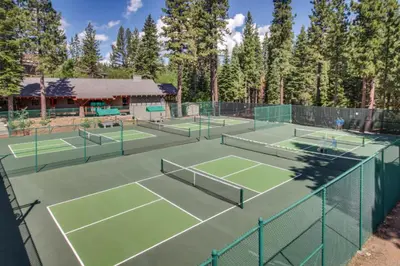 a couple of tennis courts with trees in the background at Silver Star Retreat in Ponderosa Fairway Estates