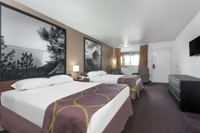 a hotel room with two beds and a flat screen tv at Super 8 by Wyndham Fernley in Fernley