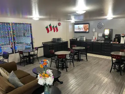 a waiting room with tables and chairs and a kitchen at Super 8 by Wyndham Fernley in Fernley