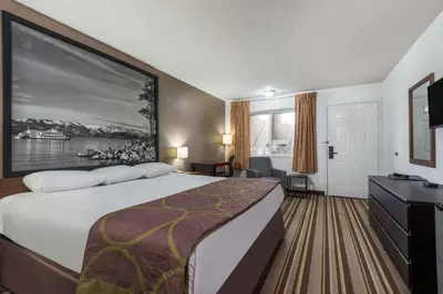 a hotel room with a large bed and a desk at Super 8 by Wyndham Fernley in Fernley
