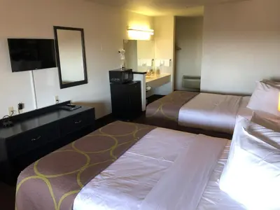 a hotel room with two beds and a mirror at Super 8 by Wyndham Fernley in Fernley