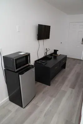 a living room with a microwave and a tv at Super 8 by Wyndham Fernley in Fernley