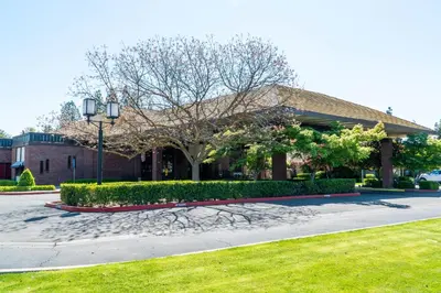 a building with a tree in the middle of a street at Hotel Piccadilly in Fresno