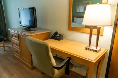 a room with a desk with a television and a telephone at Hotel Piccadilly in Fresno