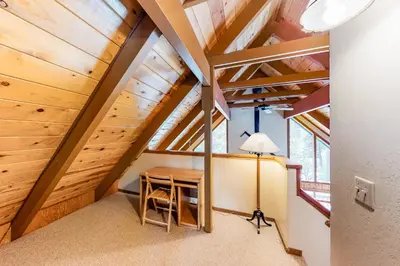 an attic room with a table and a lamp at Pine Paradise in Camp Connell