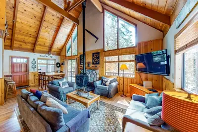 a living room with couches and a television in a cabin at Pine Paradise in Camp Connell