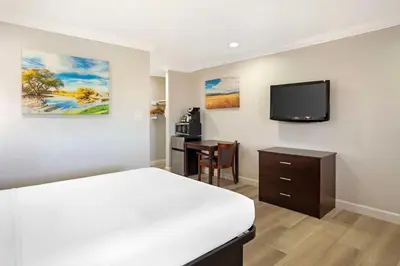 a bedroom with a bed and a desk and a television at Best Western Inn in Merced