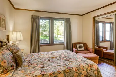 a bedroom with a bed and a chair and a window at Skyland Retreat - Max nighttime occupancy of 8 in Zephyr Cove