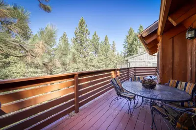 a patio with a table and chairs on a wooden deck at Skyland Retreat - Max nighttime occupancy of 8 in Zephyr Cove
