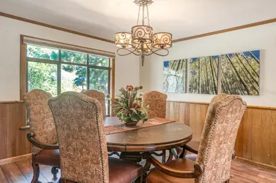 a dining room with a table and chairs and windows at Skyland Retreat - Max nighttime occupancy of 8 in Zephyr Cove
