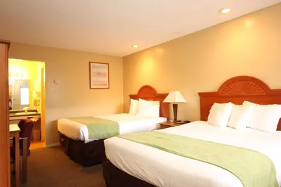 a hotel room with two beds and a bathroom at Oakhurst Lodge in Oakhurst