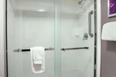 a shower with a glass door and white towels at La Quinta by Wyndham Rancho Cordova Sacramento in Rancho Cordova