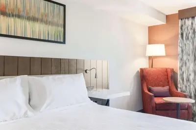 a hotel room with a bed and a chair at Hilton Garden Inn Reno in Reno