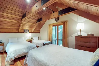 two beds in a bedroom with wooden ceilings at Timeless in Tahoma in Tahoma