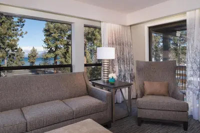 a living room with a couch and a chair and windows at Hotel Azure in South Lake Tahoe