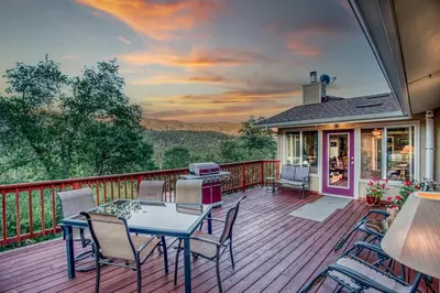 a patio with a table and chairs on a deck at A Bed of Roses in Yosemite Forks