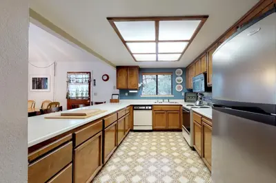 a kitchen with wooden cabinets and a stainless steel refrigerator at Cozy Chalet (15-013) in Groveland